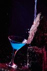 Glass of Blue Lagoon alcoholic cocktail placed on rough stone in bright studio — Stock Photo
