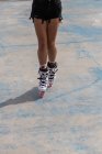 Crop gambe femminili anonime in pale a rulli bianchi con ruote rosa in piedi su marciapiede di cemento in skate park — Foto stock