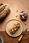 Draufsicht auf Toast mit Käsewürfeln und Pilzscheiben, serviert auf Teller in der Nähe von Brot und Schüssel mit Knoblauch in der Küche — Stockfoto