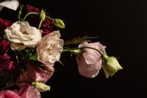 Bouquet de fleurs fraîches y compris les roses et les lis blancs eustoma et aster dans un vase en verre au soleil — Photo de stock