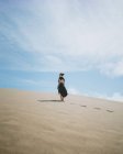 Corpo inteiro visão traseira de fêmea descalça irreconhecível no vestido passeando na duna arenosa no deserto — Fotografia de Stock
