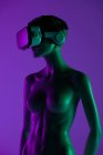 Manequim feminino com óculos VR colocados contra fundo roxo brilhante como símbolo da tecnologia futurista — Fotografia de Stock