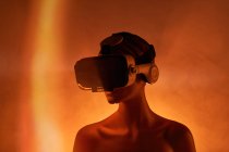 Manequim feminino com óculos VR colocados contra fundo laranja brilhante como símbolo da tecnologia futurista — Fotografia de Stock