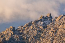 Pedras duras cobertas de musgo e arbustos localizados no topo da montanha nevada no Parque Nacional Sierra de Guadarrama, em Madrid, Espanha — Fotografia de Stock