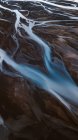 Vista aérea pitoresca de rios curvilíneos que fluem através de terrenos montanhosos selvagens na Islândia — Fotografia de Stock