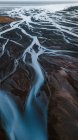 Vue aérienne pittoresque de rivières sinueuses traversant un terrain montagneux sauvage en Islande — Photo de stock