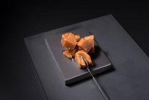 Из выше изысканной айвы желе пасты в керамической пластины на черном фоне с ложкой — стоковое фото