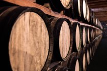 Aged wine cellar rows of barrels on shelves — Stock Photo