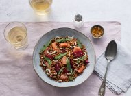 Closeup of a salmon and lentil salad seen from above on a table with a pink tablecloth — Stock Photo