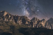 Landschaft Blick auf den Sternenhimmel mit Galaxie und interstellarem Gas über herrliche Bergrücken bei Sonnenuntergang — Stockfoto