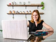 Graphic designer femminile che utilizza netbook e tablet con stilo mentre lavora al progetto a tavola in studio creativo — Foto stock
