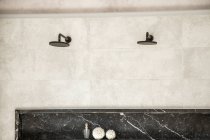 Интерьер ванной комнаты с душевой кабиной с черными ручками крана и шлангом на белых стенах — стоковое фото