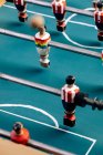 Высокий угол детализации ретро настольного футбола с деревянными миниатюрными фигурками игроков на металлических брусьях — стоковое фото