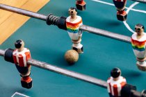 Высокий угол детализации ретро настольного футбола с деревянными миниатюрными фигурками игроков на металлических брусьях — стоковое фото