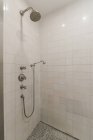 Diseño interior moderno de estilo minimalista de baño con paredes de azulejos blancos y ducha en esquina - foto de stock