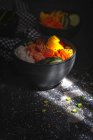 Grand angle de poke asiatique au saumon et riz avec des légumes variés servis dans un bol sur la table au restaurant — Photo de stock