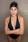 Portrait of beautiful young swimmer woman with black swimwear hat and swimming goggles — Stock Photo