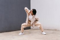 Talentierte Tänzerin bewegt sich und tanzt in der Nähe einer Betonmauer im Stadtgebiet — Stockfoto