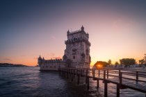 Narrow quay located near famous Belem Tower on shore of Tagus River against cloudy sundown sky in Lisbon, Portugal — Stock Photo