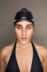 Retrato de bela jovem nadadora com chapéu de banho preto e óculos de natação — Fotografia de Stock