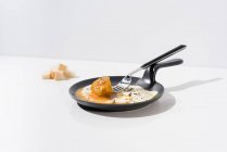 Brotstücke auf weißem Tisch mit leckerem Spiegelei auf Pfanne mit Gabel — Stockfoto