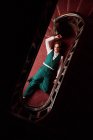 Vue de dessus d'un acteur masculin talentueux couché sur le sol près d'un escalier et faisant semblant d'être mort lors d'une performance créative — Photo de stock