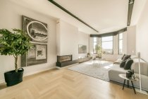 Interior contemporáneo de amplio salón con cómodo sofá y chimenea en piso diseñado en estilo minimalista - foto de stock