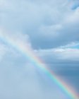 Majestic drone view of colorful rainbow in blue sky with clouds at daytime — Stock Photo