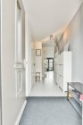 Vista prospectiva do corredor com mobiliário branco minimalista e design de interiores em apartamento estilo loft moderno — Fotografia de Stock