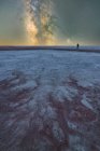 Силуэт исследователя, стоящего в сухой соленой лагуне на фоне звездного неба с светящимся Млечным Путем ночью — стоковое фото