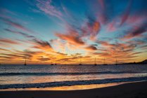Sundown sky with vivid orange clouds located over sea water with boats in evening in Fuerteventura, Spain — Stock Photo
