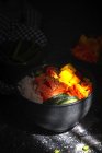 Grand angle de poke asiatique au saumon et riz avec des légumes variés servis dans un bol sur la table au restaurant — Photo de stock