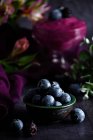 Primo piano di mucchio di mirtilli maturi in ciotola serviti su tavola nera con panno viola — Foto stock