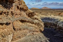 Rough stony surface located near path on cloudy summer day in nature of Fuerteventura, Spain — Stock Photo