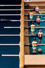 Grand angle de détail du baby-foot rétro avec figurines miniatures en bois de joueurs sur barres métalliques — Photo de stock