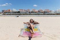 De cima fêmea feliz em maiô deitado no colchão inflável na praia de areia e banhos de sol no dia ensolarado durante as férias de verão — Fotografia de Stock