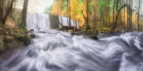 Vista panorâmica do monte com cascatas e rio com fluidos de água espumosos sobre pedras entre árvores de outono em Lozoya, Madri, Espanha. — Fotografia de Stock
