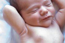 Vista superior de bonito pequeno bebê recém-nascido nu adorável dormindo deitado em cama macia em casa — Fotografia de Stock