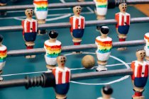 Hohe Detailgenauigkeit des Retro-Tischkickers mit hölzernen Miniaturfiguren von Spielern auf Metallstangen — Stockfoto