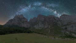 Vista panoramica del cielo stellato con galassia e gas interstellare su magnifiche creste al tramonto — Foto stock