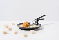 Шматочки хліба, які подаються на білому столі з апетитом смажене яйце на сковороді з виделкою — стокове фото