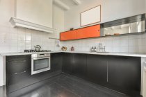 Interior of modern kitchen with dark gray furniture in apartment in minimal style — Stock Photo