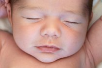 Top view of cute small adorable naked newborn baby sleeping lying on soft bed at home — Stock Photo