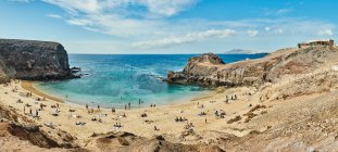 Drone view of sandy beach with tourists located near calm sea with clean turquoise water on sunny summer day in Fuerteventura, Spain — Stock Photo