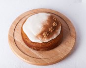 Top view of tasty carrot cake with walnuts and cinnamon powder on icing sugar glaze on light background — Stock Photo