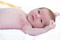 Entzückend nackt im Säugling liegend auf weichem Bett zu Hause — Stockfoto