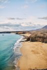 Drone vista da praia de areia com água azul-turquesa limpa no dia ensolarado de verão em Fuerteventura, Espanha — Fotografia de Stock