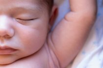 Vista superior de lindo pequeño adorable bebé recién nacido desnudo durmiendo acostado en la cama suave en casa - foto de stock