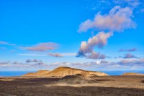 Weitwinkelblick auf felsige, trockene Hügel im Hochland gegen bewölkten Himmel im Sommer auf Fuerteventura, Spanien — Stockfoto