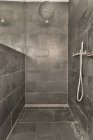 Інтер'єр сучасної ванної кімнати з сірими стінами і підлогою, спроектований в мінімальному стилі — стокове фото